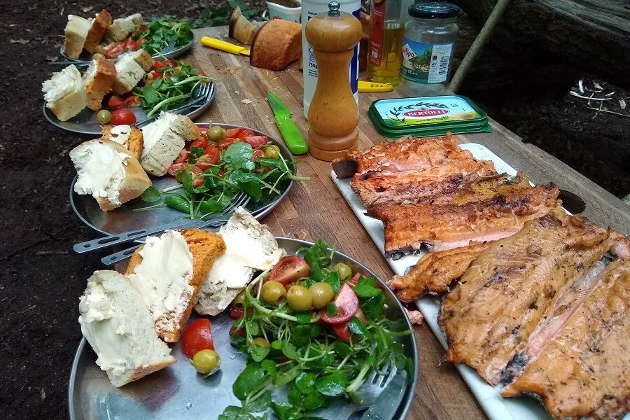 Trout with salad and freshly baked bread - lunch in the woods